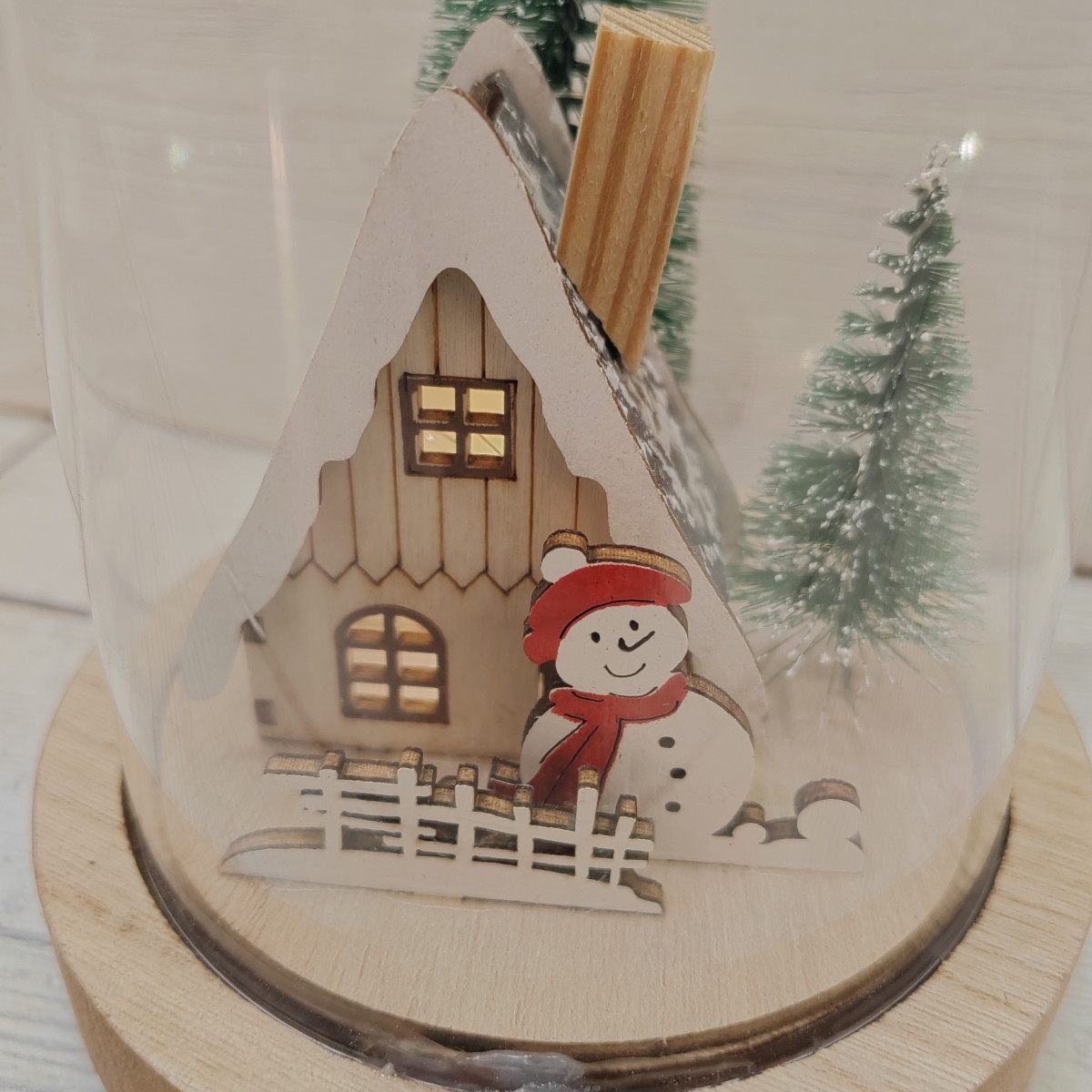 Paesaggio in legno con pupazzo di neve