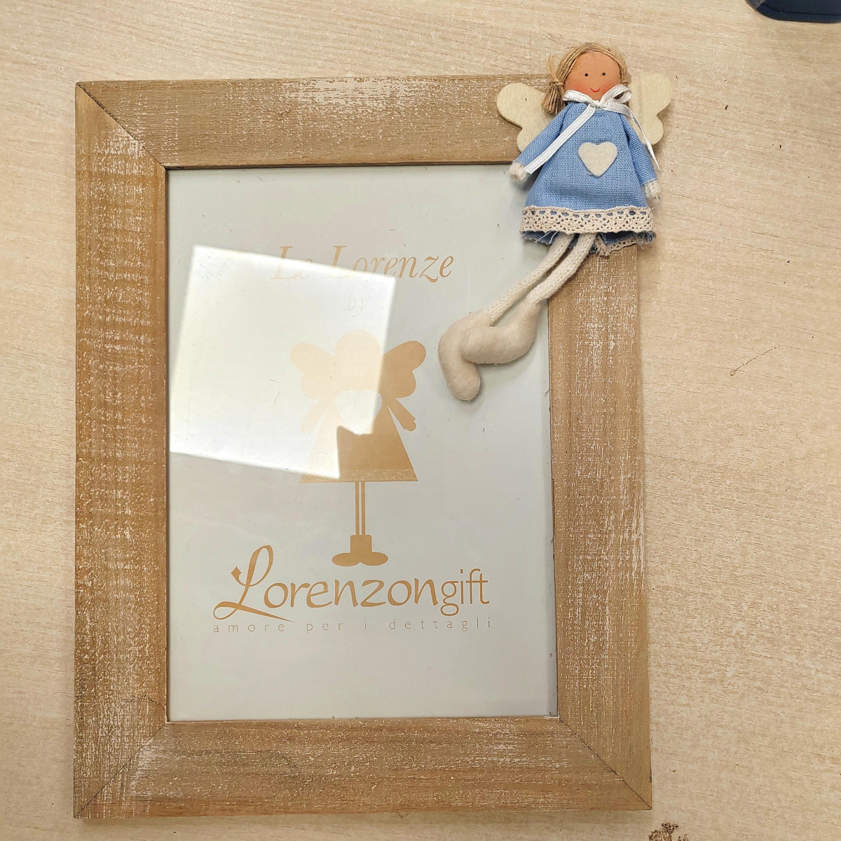 Cornice con bambolina azzurra